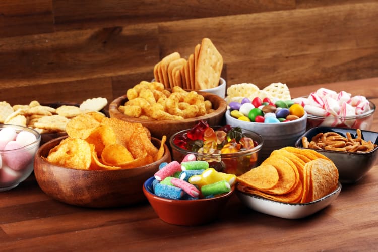 A selection of chips and candy in wooden bowls
