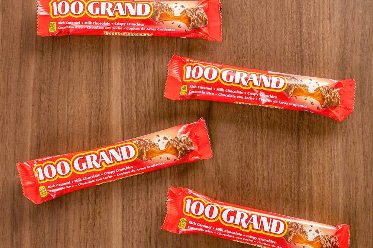 Four 100 Grand Bars on a wooden table