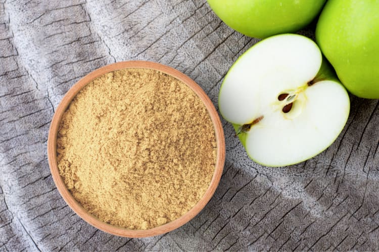 A bowl of pectin powder next to apples
