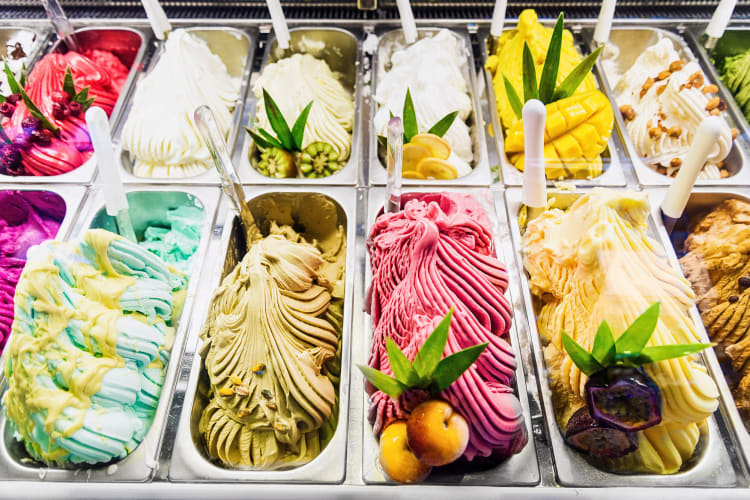 Different flavors of gelato in serving tubs