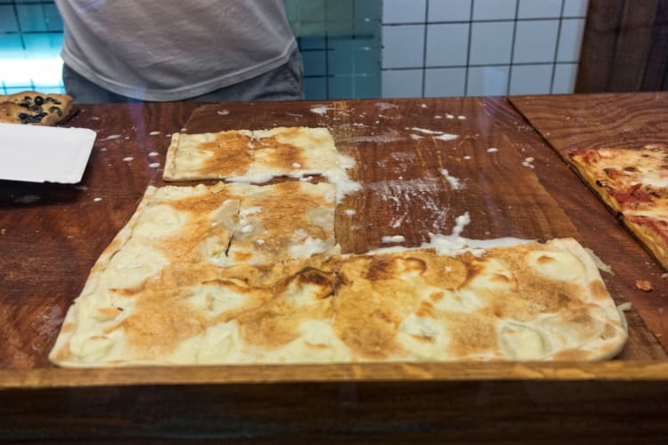 A pizza-style dish in a serving case
