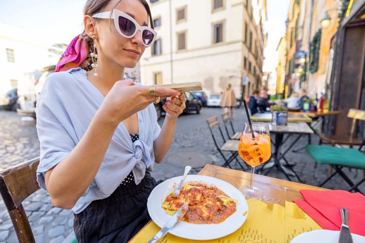 Woman eating a meal at a restaurant on the streets of Rome
