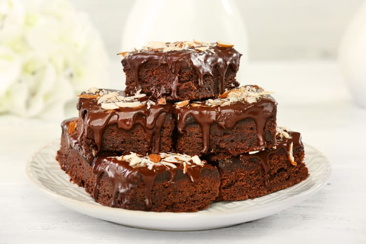 Side-view of dark chocolate brownies with melted sauce on top