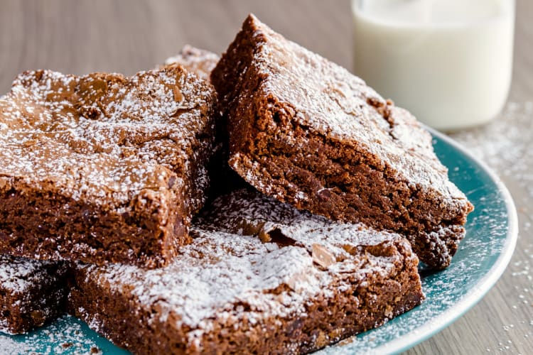 Four brownies made from the best brownie mix with coconut shavings on top