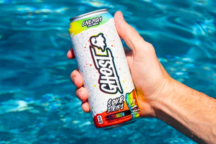 A person in a pool holding a white energy drink with rainbow design