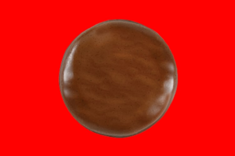 A chocolate covered cookie on a red background