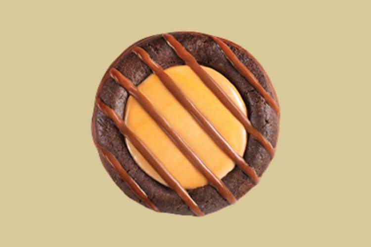A chocolate cookie with a caramel cream filling