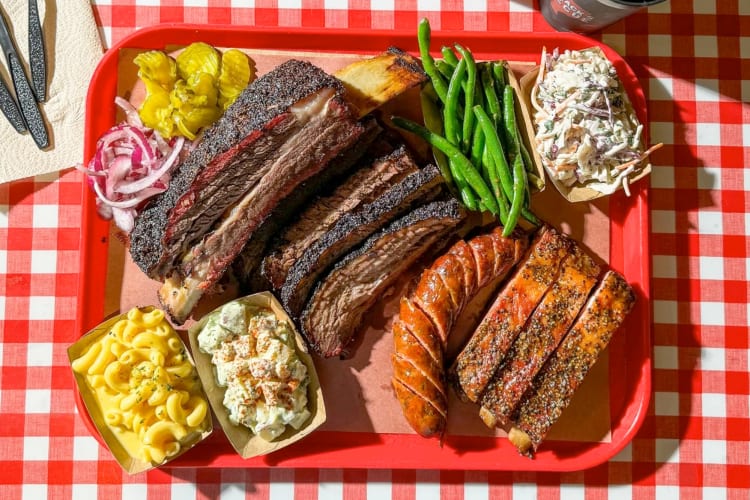 Barbecued meats and sides on a red tray
