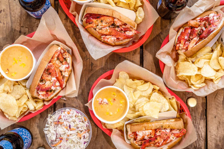Lobster rolls and chips in red baskets on a table