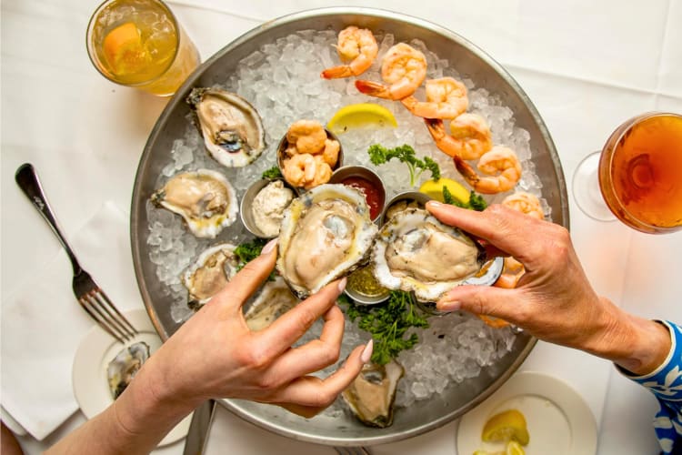 People eating oysters from a seafood platter