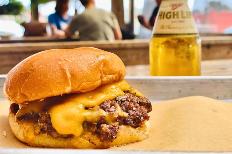 Side view of a burger with melted cheese, from Goodfriend Beer Garden and Burger House, a place that sells fast food in Dallas
