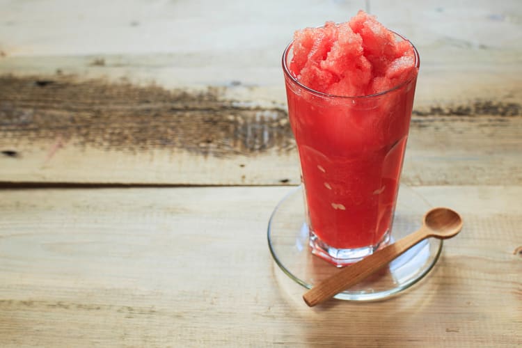 Glass of granita with a wooden spoon resting next to it
