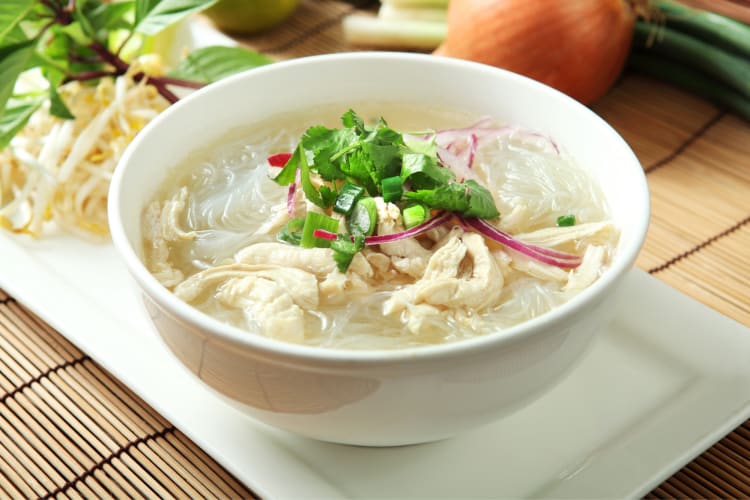 A bowl of noodle soup with a clear broth
