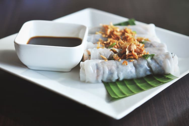 Rice paper rolls on a plate next to a dipping sauce