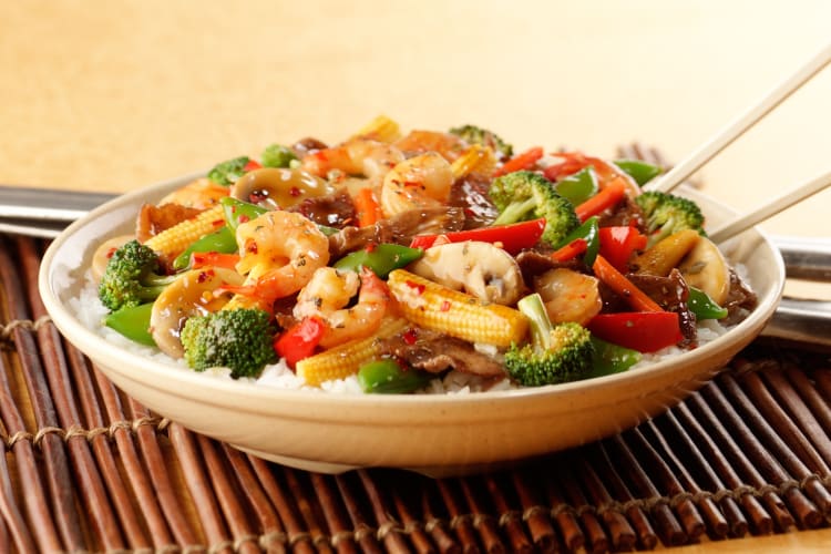 A bowl of stir-fried shrimp and vegetables