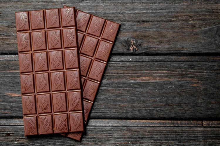 Two bars of chocolate on a wooden surface