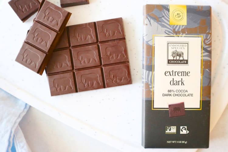 A chocolate bar next to dark chocolate with elephants on it
