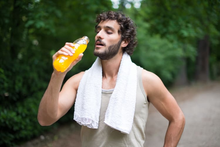 A man drinking an energy drink after a workout