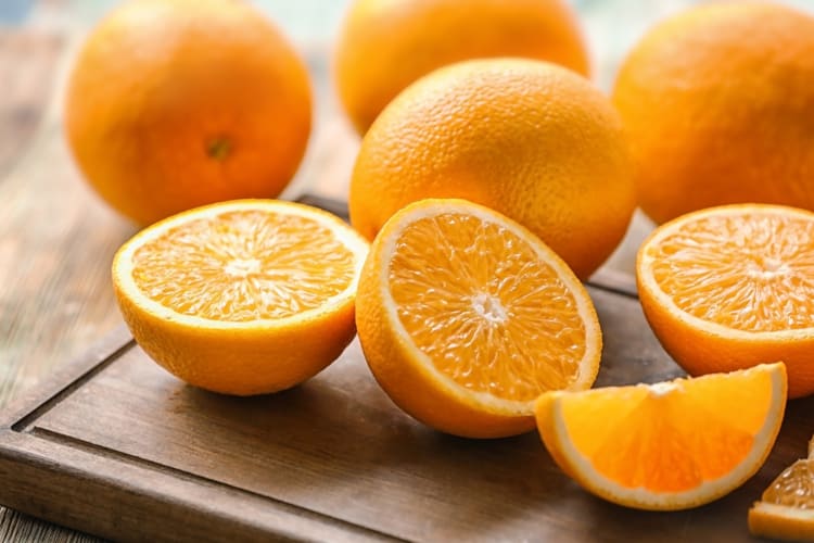 Whole and halved oranges on a table