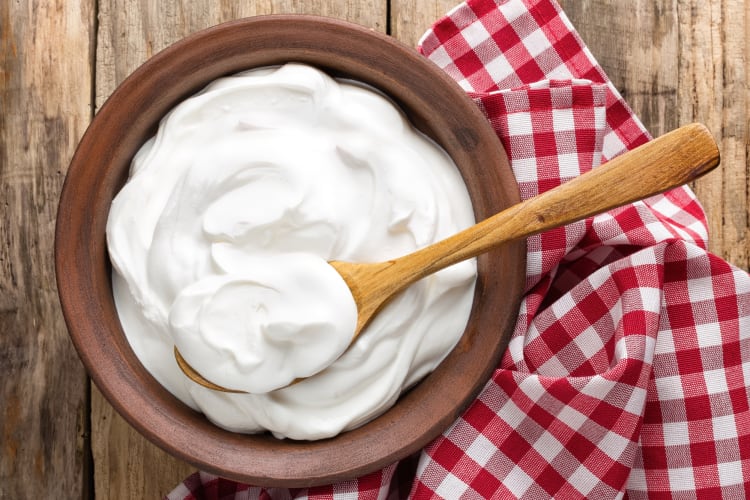 A bowl of Greek yogurt on a red and white cloth