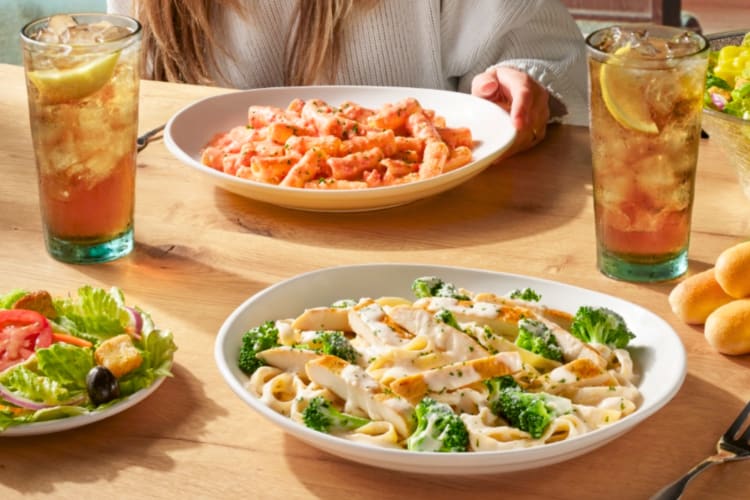 A selection of Olive Garden dishes and iced tea on a table