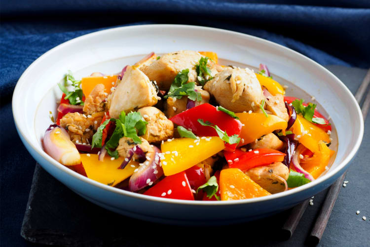 A bowl of stir-fry with chicken and vegetables