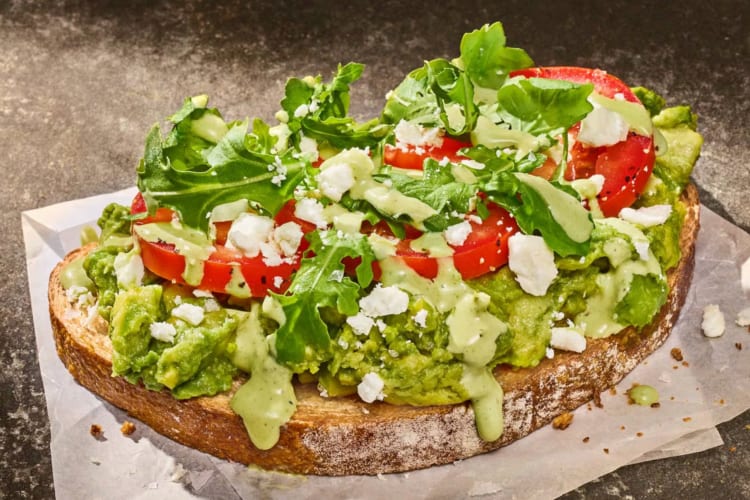 Avocado toast with feta, arugula and tomatoes