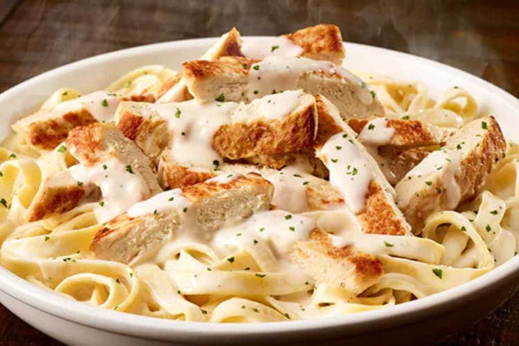 A dish of fettuccine Alfredo with grilled chicken