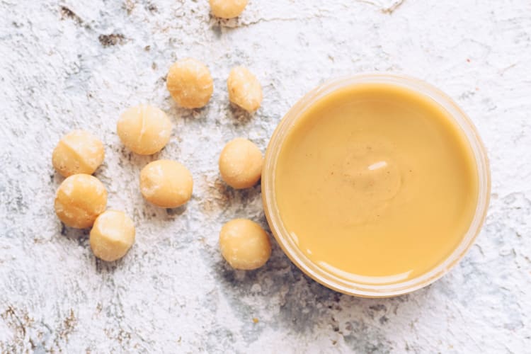 Fresh macadamia nuts and a tub of macadamia nut butter