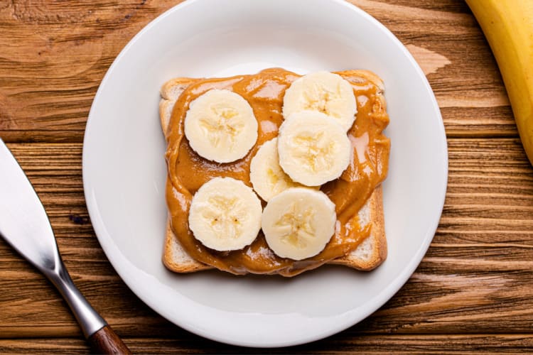 A slice fo bread with peanut butter and banana slices
