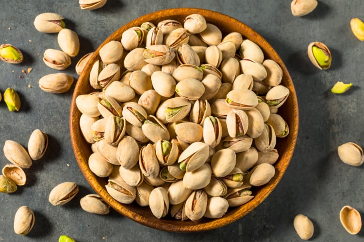 A bowl of pistachios in the shells
