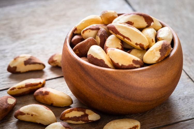 A wooden bowl of Brazil nuts