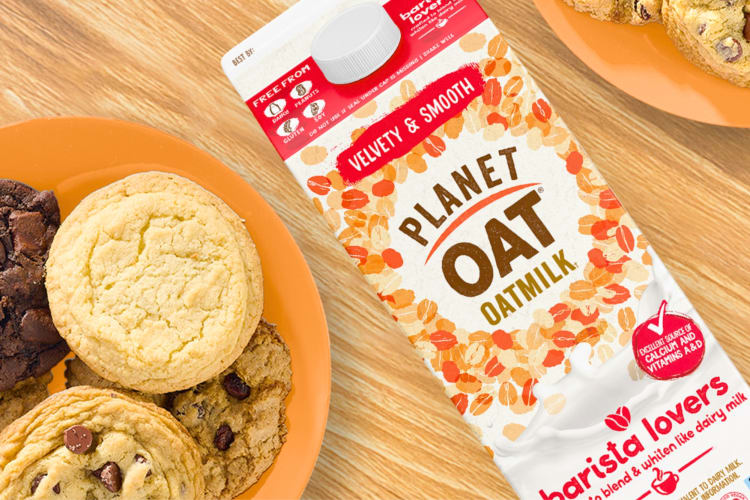 A carton of at milk next to a plate of cookies