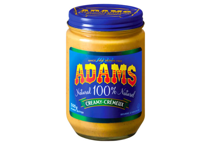 A glass jar of peanut butter with a blue lid and label