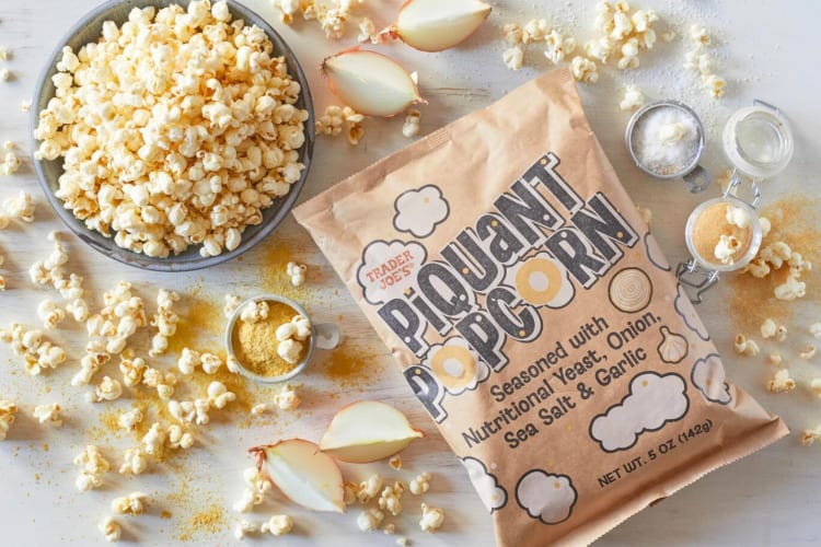 A bag of popcorn surrounded by popcorn kernels