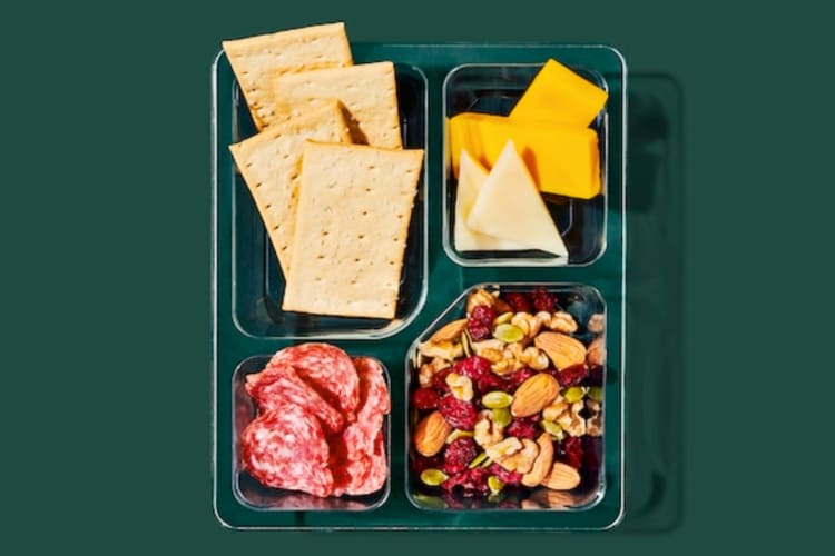 A snack box with salami, cheese, crackers and trail mix