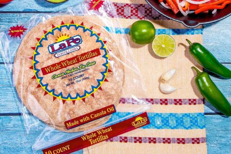 A bag of tortillas next to fresh limes and jalapeños