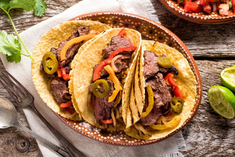 Steak tacos next to squeezed limes