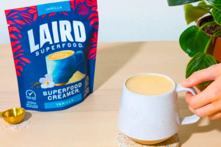 A bag of Laird coffee creamer next to a cup of coffee