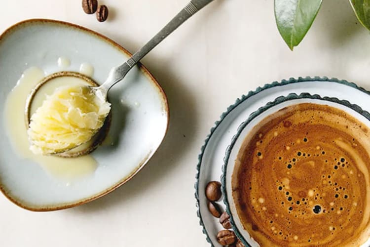 A bowl of ghee next to a cup of coffee