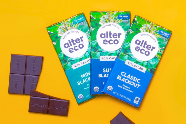 Three blue and green chocolate bar packets next to dark chocolate