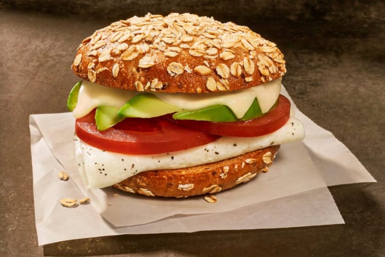 A multigrain bagel filled with egg and avocado 