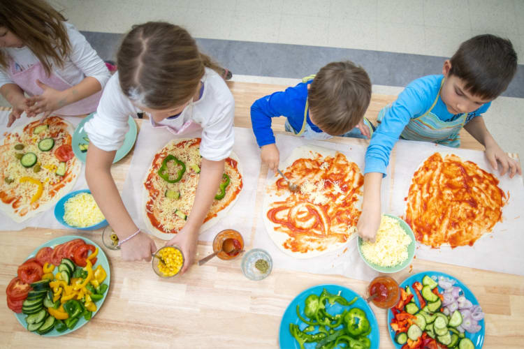 Kids making pizza in a cooking class