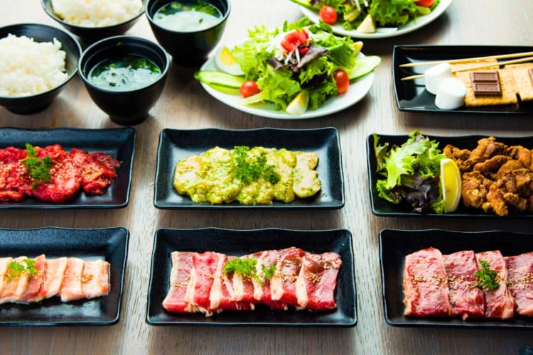 A selection of meats, rice and vegetables on a table