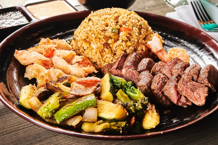 A plate with hibachi rice, meat and vegetables