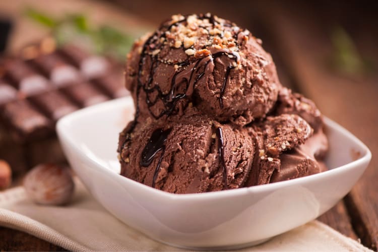 A bowl of chocolate ice cream with hazelnuts