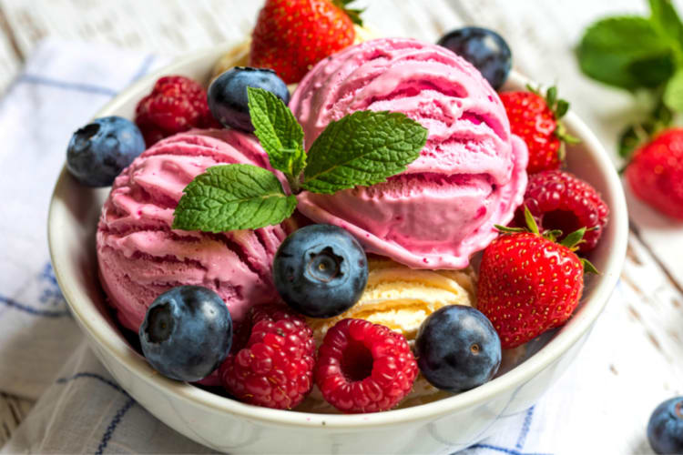 Fruit flavored ice cream in a bowl with fresh berries