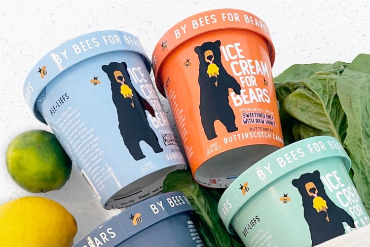 Colorful tubs of Ice Cream for Bears next to fresh citrus fruit