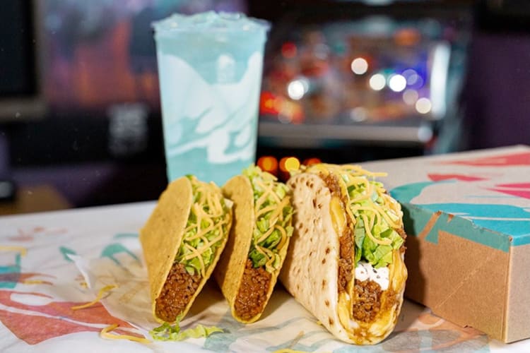 Three Taco Bell tacos next to a blue Baja Blast drink