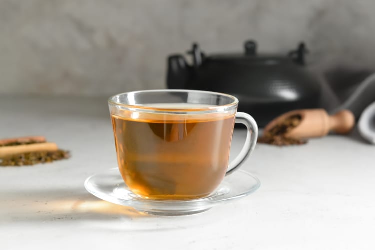 A glass cup of hojicha tea